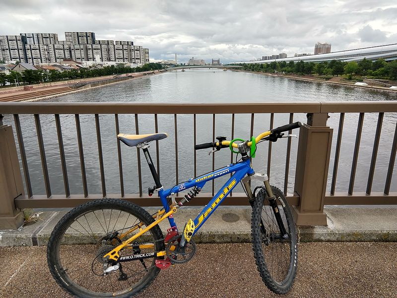 川の橋の上に停めているJamisのマウンテンバイク