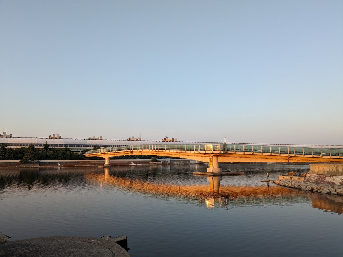 川にかかる橋。橋は朝日でオレンジ色に染まっている